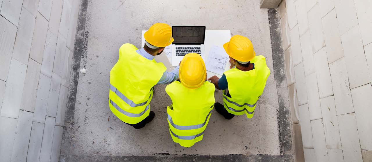 Construction Workers looking at an Equipment Share Tracking System on Laptop