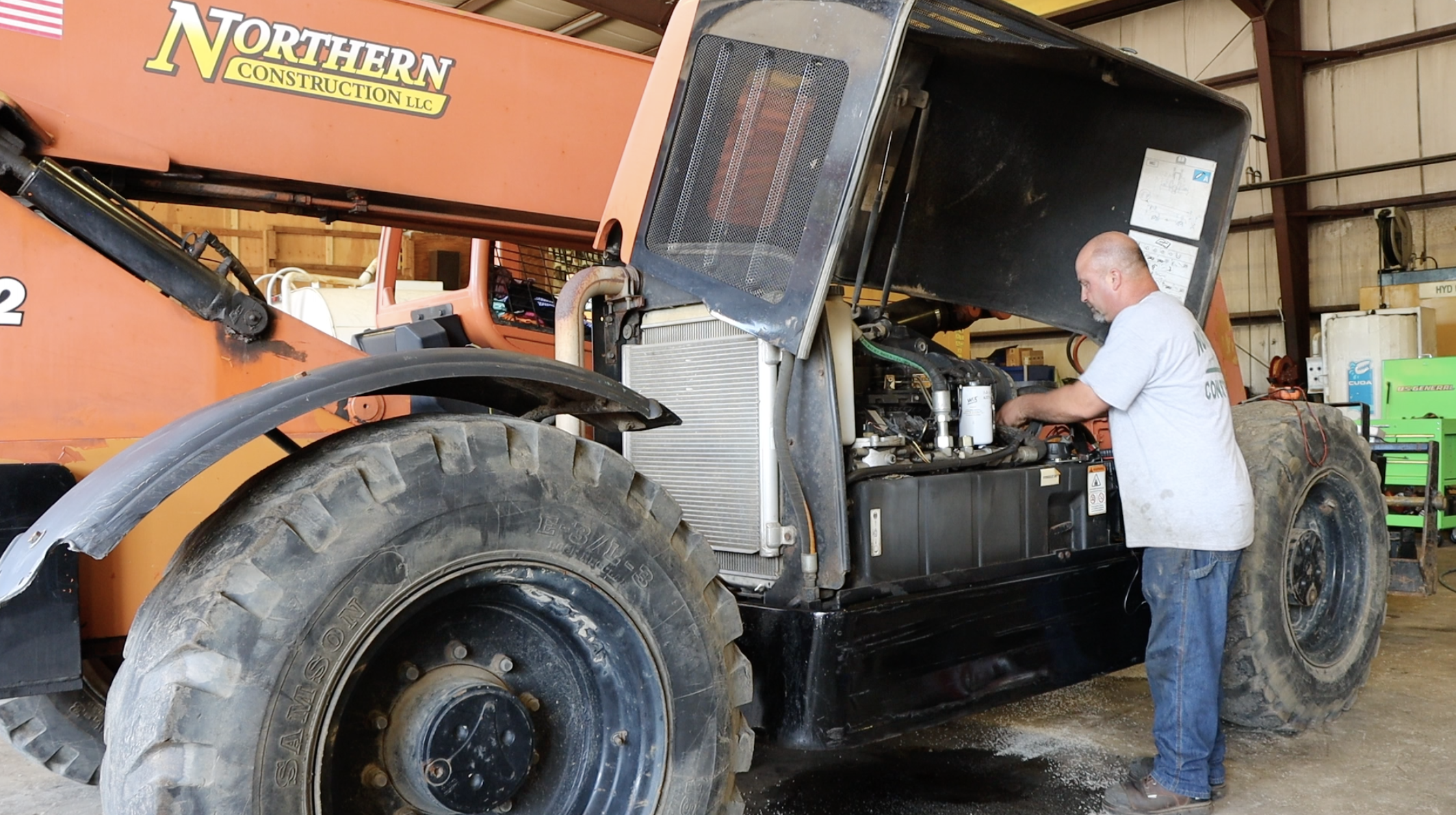 Northern Construction employee doing maintenance on a piece of equipment