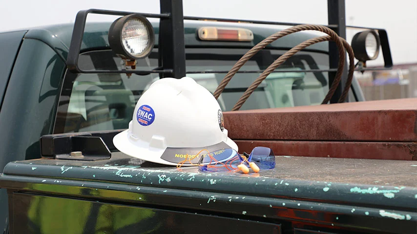Hard hat resting on a truck bed in the field Hard hat resting on a truck bed in the field