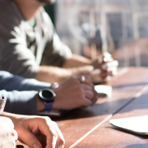 People discussing Equipment Share Trackers at a Table