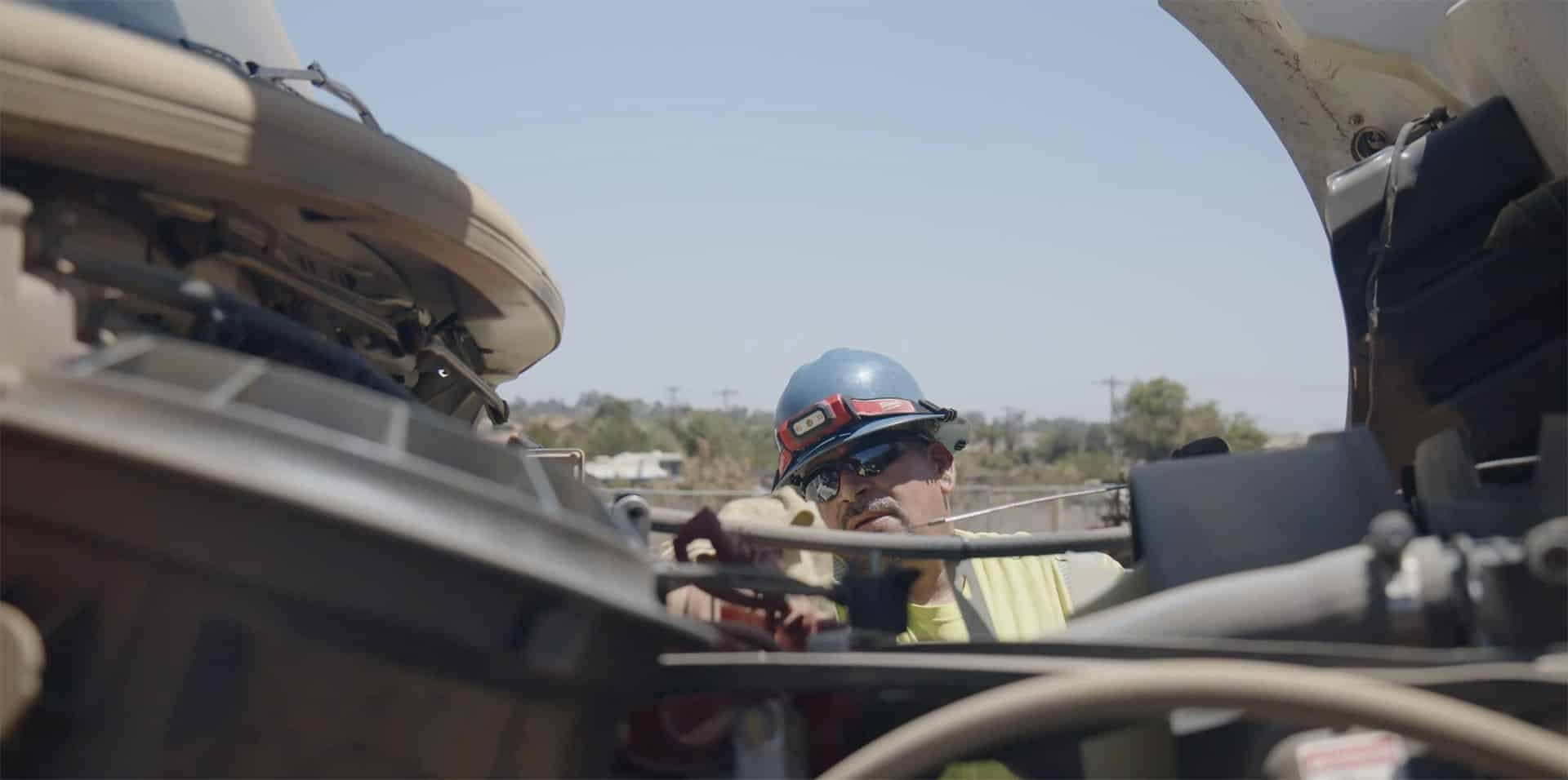 Ferreira Power West mechanic checking the oil on a truck